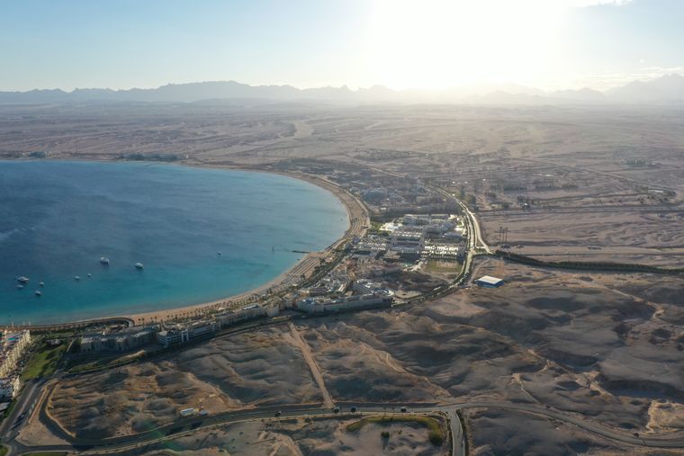 Aerial view of a turquoise bay, resorts and desert hills on the coast near Hurghada