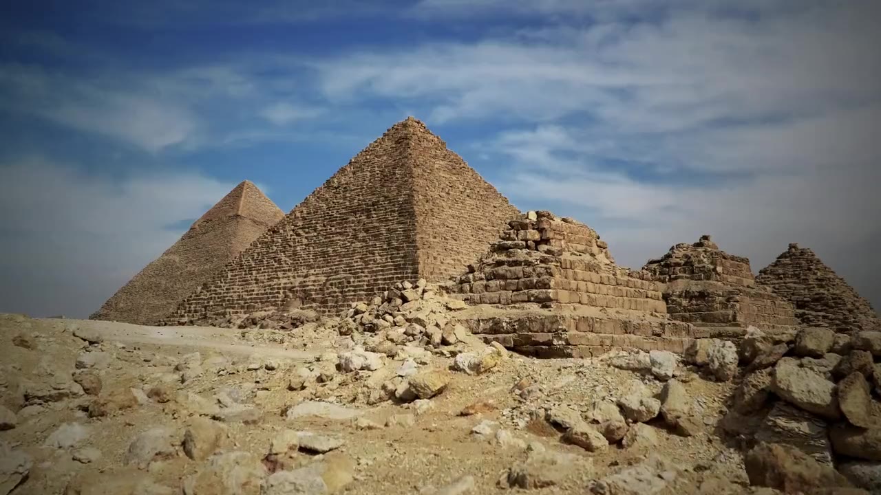 The pyramids of Giza and the small queens' pyramids under a cloudy sky